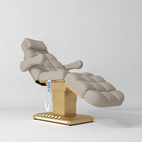 Manufakturo Orielle B Stone Taupe electric beauty bed with gold base and current hand-held controller.