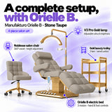 Manufakturo Orielle B Stone Taupe four-piece salon set features: electric bed with three motors and hand and foot controls, height-adjustable Noblesse swivel chair, V3 Pro Gold lamp and three-tier gold trolley.
