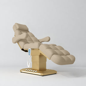 Manufakturo Orielle B Warm Beige electric beauty bed with gold base and current hand-held controller.