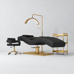 Manufakturo Prestige Black studio set with hydraulic lash bed, Serenity chair, V3 Pro Gold lamp and empty gold trolley.