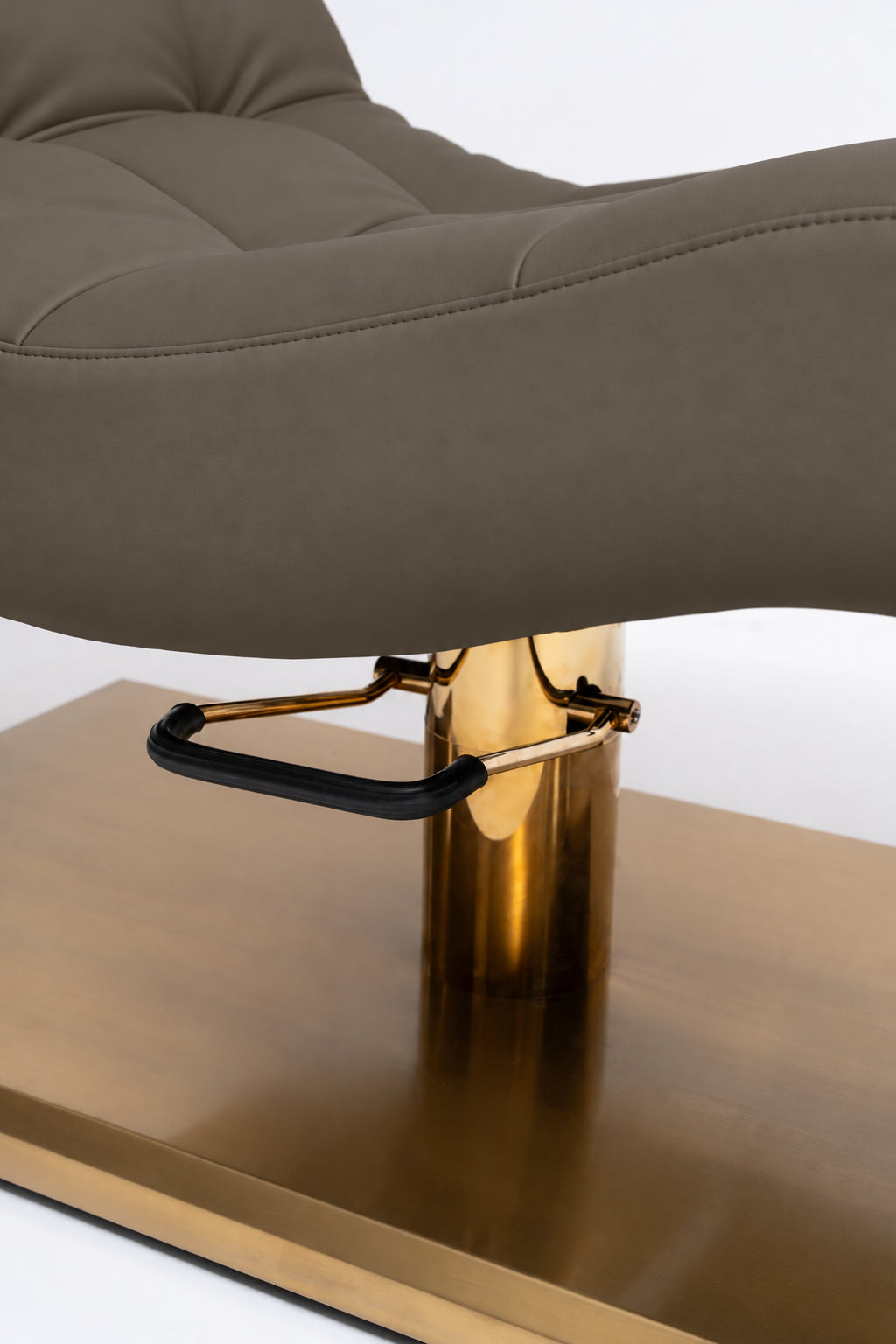 Manufakturo Prestige Cocoa Mocha close-up of upholstered stitching, gold hydraulic column and black foot pedal.