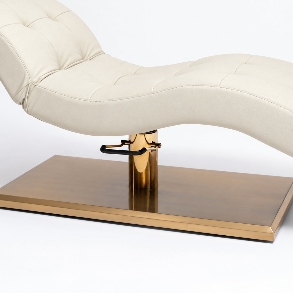 Manufakturo Prestige Creamy upholstered bed close-up with gold hydraulic pump, black foot pedal and rectangular gold base.