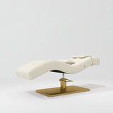 Manufakturo Prestige Creamy hydraulic eyelash bed, three-quarter side view with gold pedestal base and contoured upholstery.
