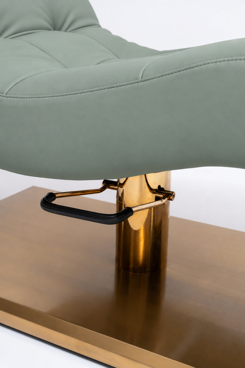 Manufakturo Prestige Olive close-up of upholstered stitching, gold hydraulic column and black foot pedal.