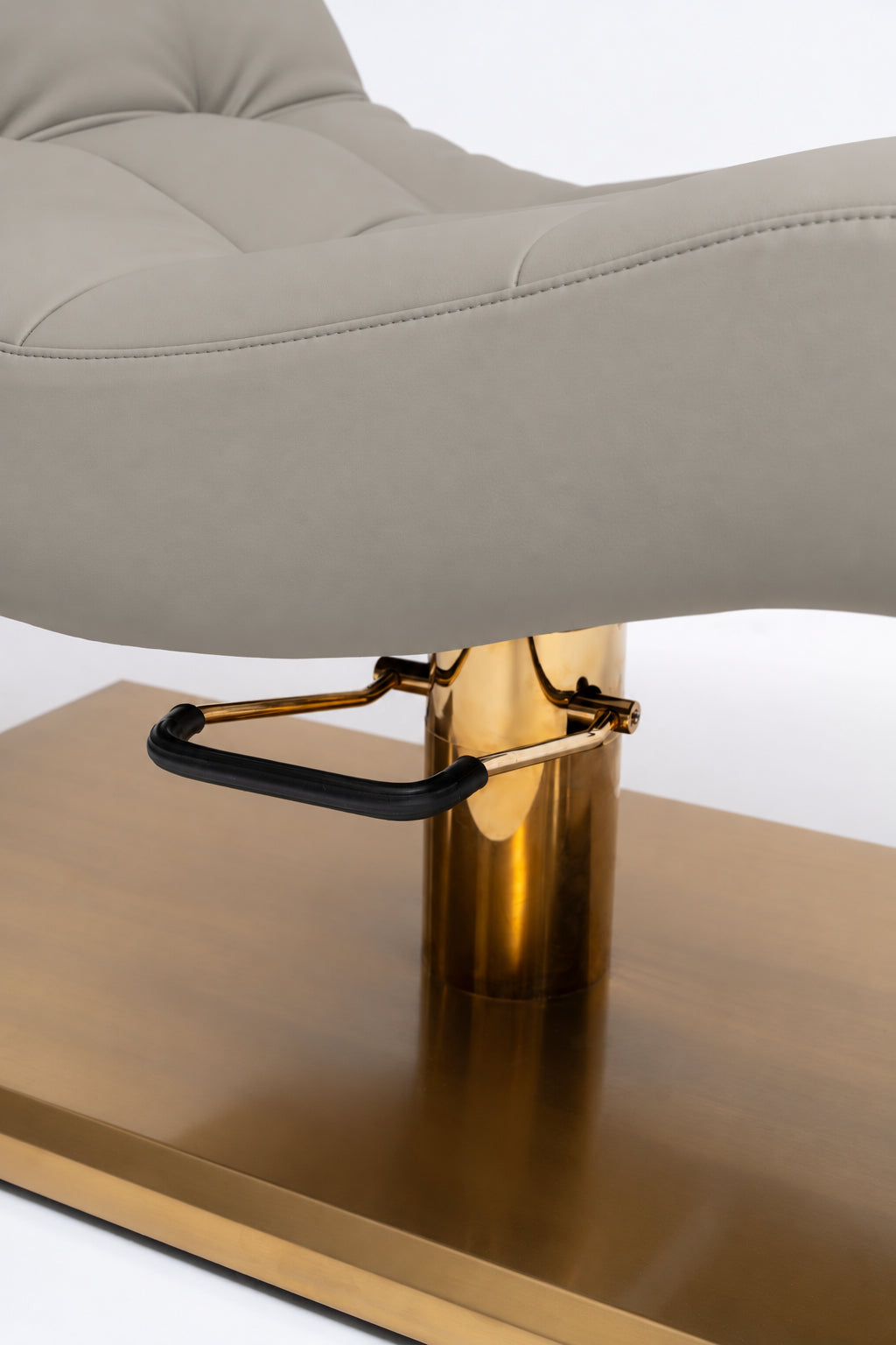 Manufakturo Prestige Pearl Greige close-up of upholstered stitching, gold hydraulic column and black foot pedal.