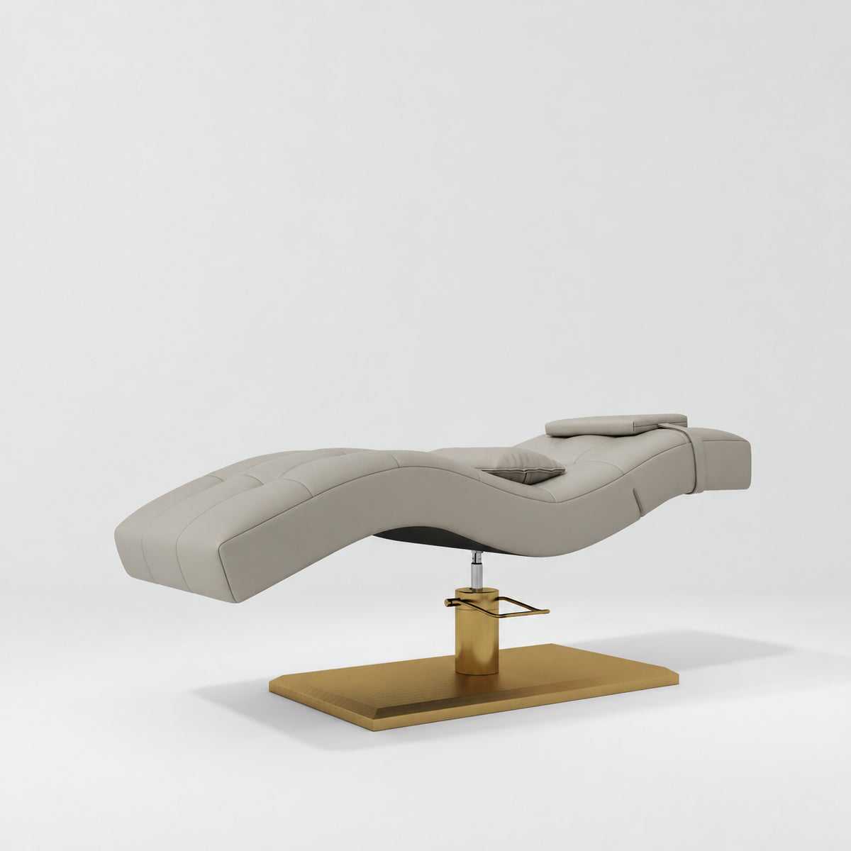 Manufakturo Prestige Pearl Greige hydraulic eyelash bed, three-quarter side view with gold pedestal base and contoured upholstery.