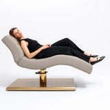 Manufakturo Prestige Stone Taupe hydraulic beauty bed with a reclining client, showing contoured upholstery and gold base.