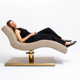 Manufakturo Prestige Warm Beige hydraulic beauty bed with a reclining client, showing the contoured support and gold base.