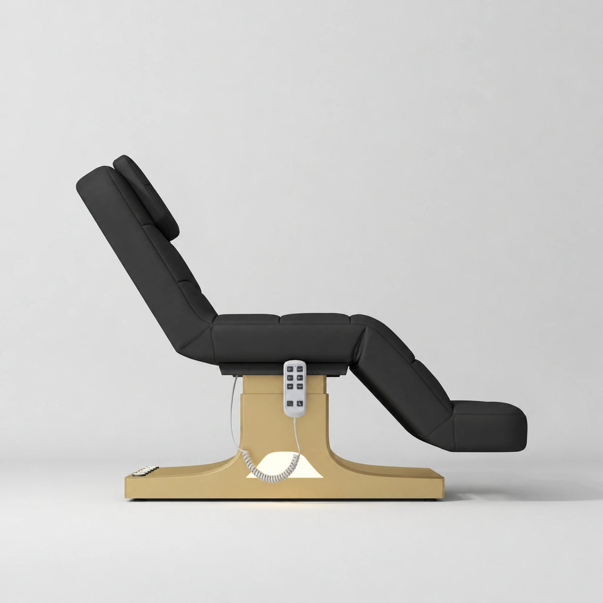 Manufakturo Saphir A Black electric beauty bed with gold base, raised treatment position shown from the side, without armrests.