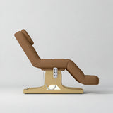 Manufakturo Saphir A Caramel electric beauty bed with gold base, raised treatment position shown from the side, without armrests.