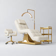 Manufakturo Saphir A Creamy four-piece beauty studio set with electric bed, Serenity salon chair, V3 Pro Gold lamp and empty three-tier gold trolley.