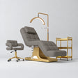 Manufakturo Saphir A Deep Ash four-piece beauty studio set with electric bed, Serenity salon chair, V3 Pro Gold lamp and empty three-tier gold trolley.