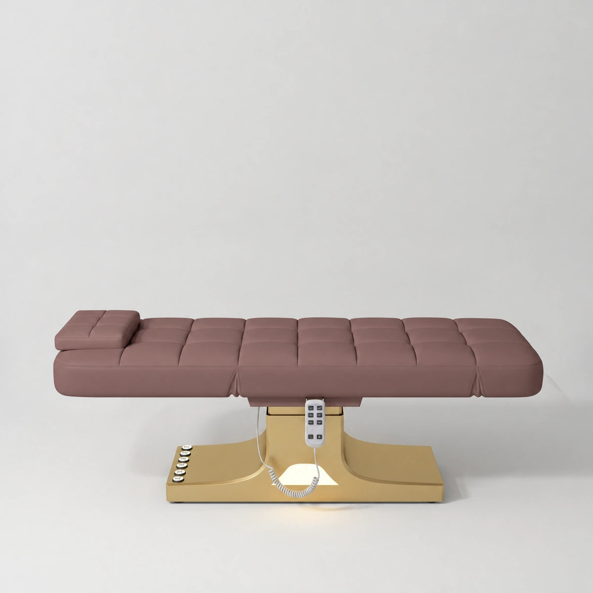 Manufakturo Saphir A Dusty Rose electric beauty bed with gold base, flat lying position shown from the side, without armrests.