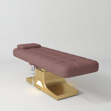 Manufakturo Saphir A Dusty Rose electric beauty bed with gold base, flat lying position shown in a three-quarter view, without armrests.