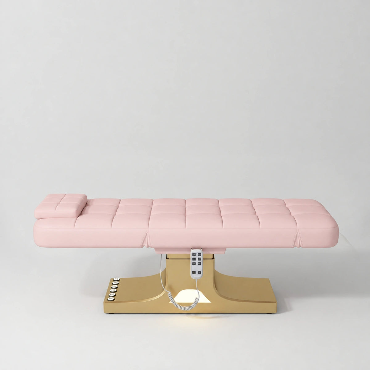 Manufakturo Saphir A Light Pink electric beauty bed with gold base, flat lying position shown from the side, without armrests.