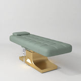 Manufakturo Saphir A Olive electric beauty bed with gold base, flat lying position shown in a three-quarter view, without armrests.