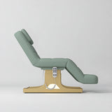 Manufakturo Saphir A Olive electric beauty bed with gold base, raised treatment position shown from the side, without armrests.