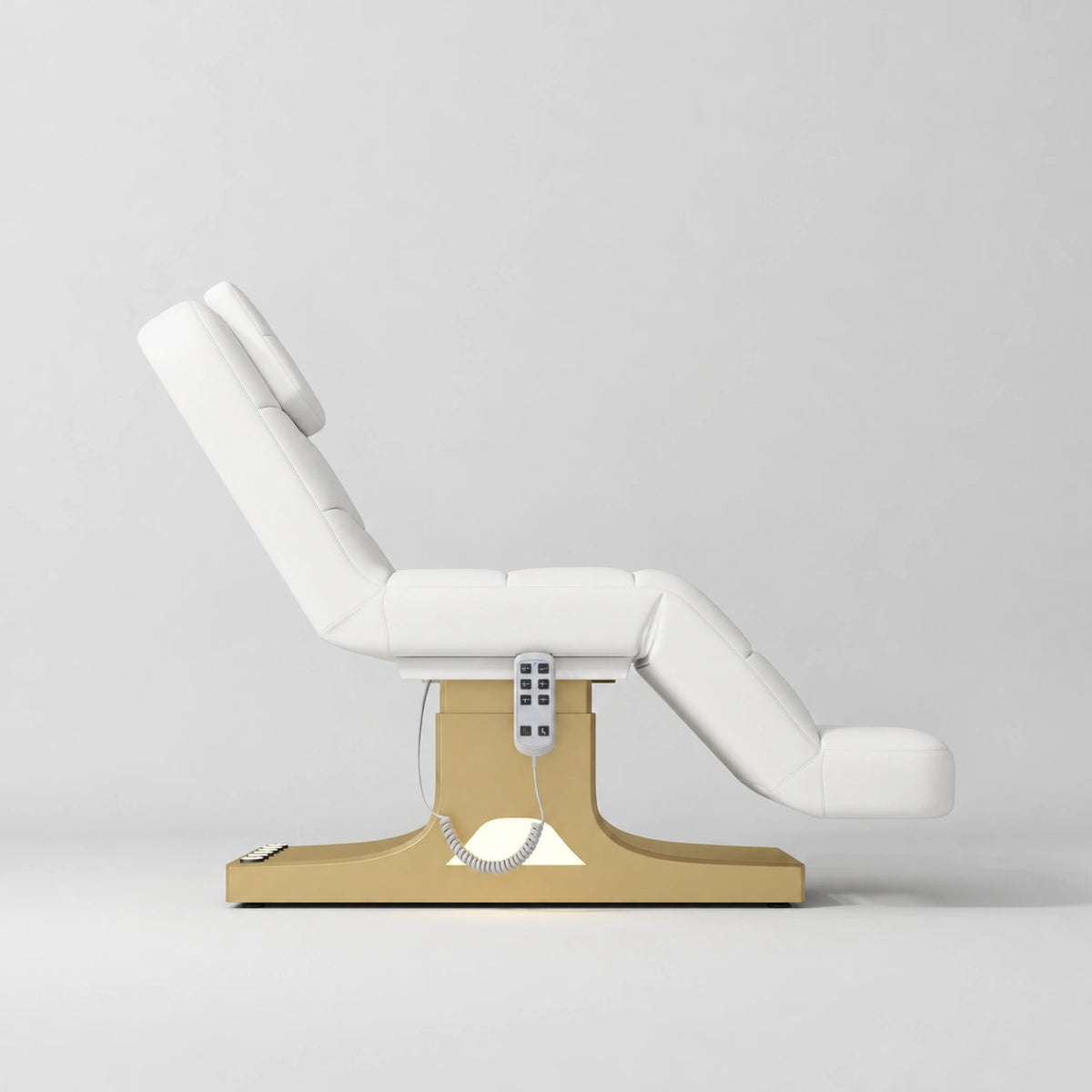 Manufakturo Saphir A White electric beauty bed with gold base, raised treatment position shown from the side, without armrests.