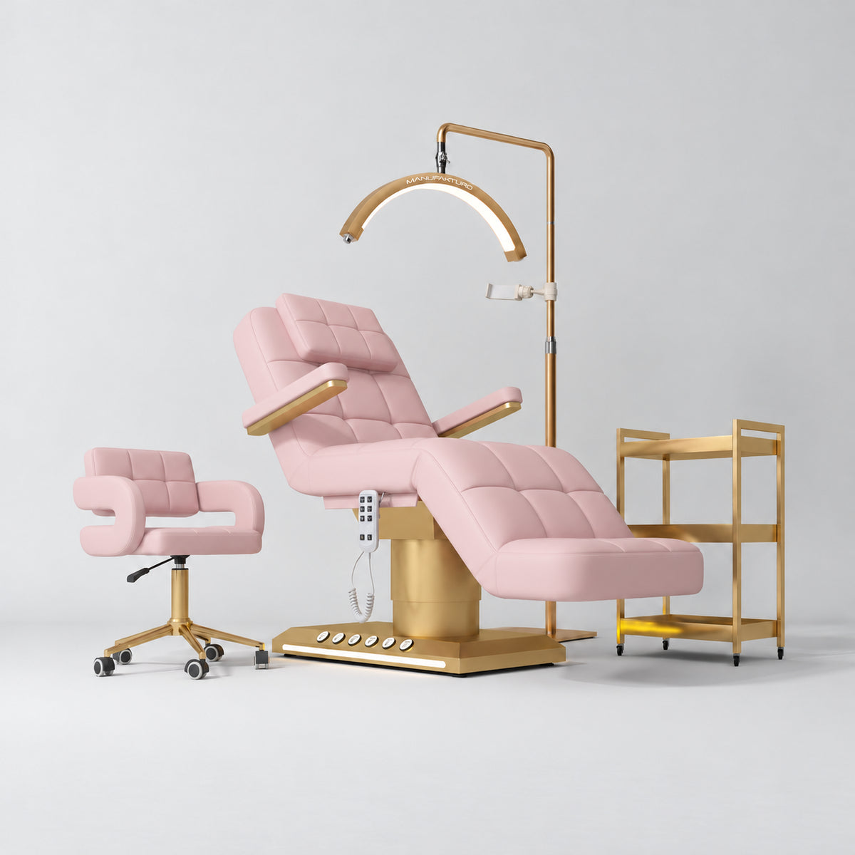 Manufakturo Saphir B Bare Blush four-piece beauty studio set with armrest electric bed, Serenity salon chair, V3 Pro Gold lamp and empty three-tier gold trolley.