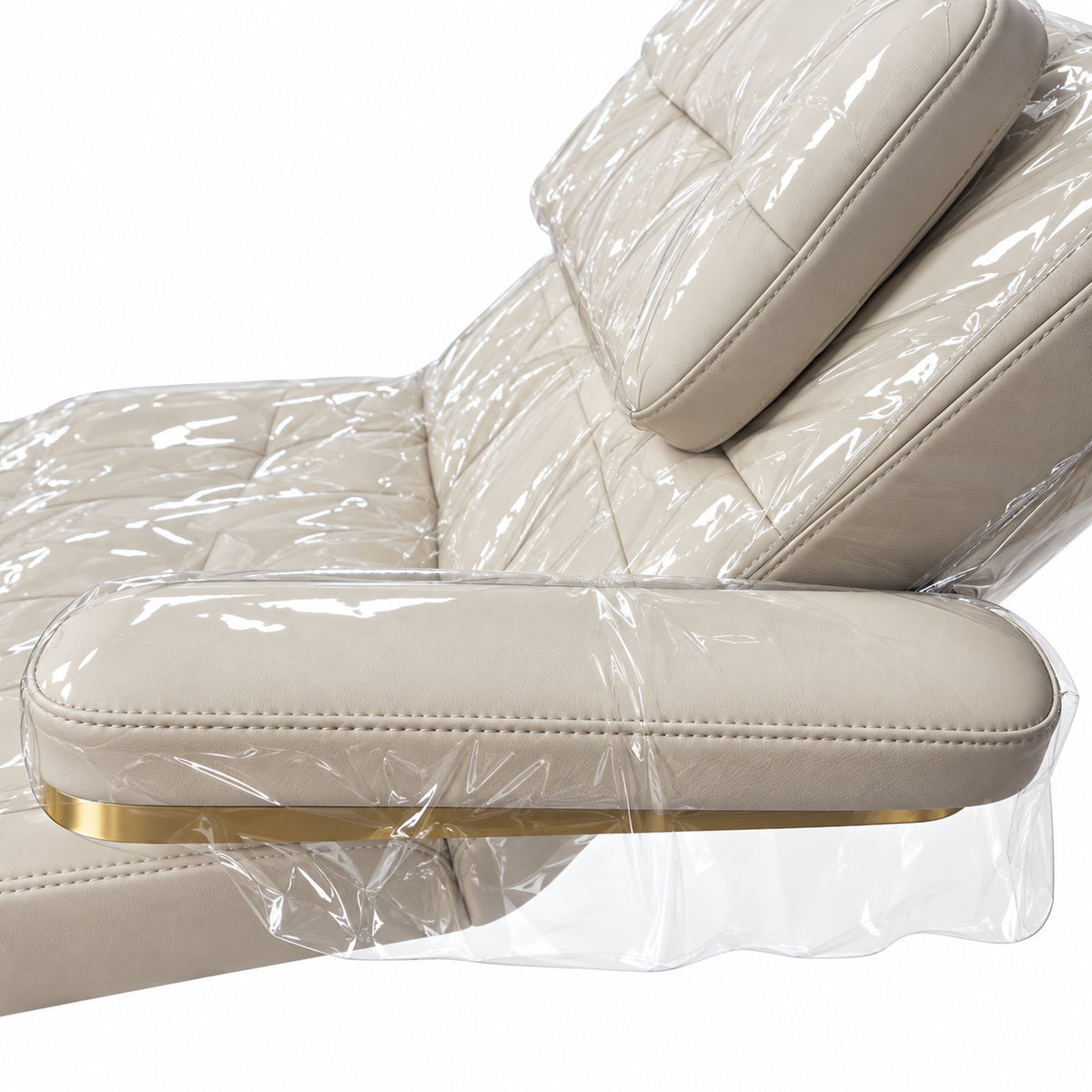 Close-up of a Saphir B cream armrest and the transparent protective cover draping over its gold trim