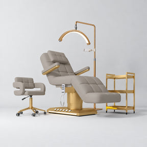 Manufakturo Saphir B Pearl Greige four-piece beauty studio set with armrest electric bed, Serenity salon chair, V3 Pro Gold lamp and empty three-tier gold trolley.