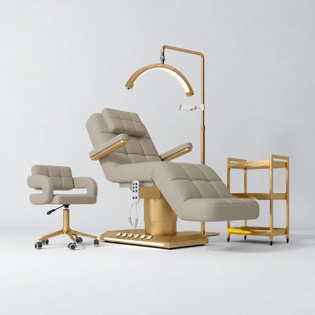 Manufakturo Saphir B Stone Taupe four-piece beauty studio set with armrest electric bed, Serenity salon chair, V3 Pro Gold lamp and empty three-tier gold trolley.