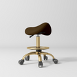 Manufakturo Selle Ergonomic Beauty Saddle Stool Cocoa Mocha - Gold Base - displayed in a professional treatment-room setting