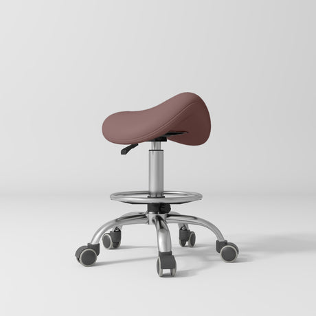 Manufakturo Selle Ergonomic Beauty Saddle Stool Dusty Rose - Silver Base - displayed in a professional treatment-room setting