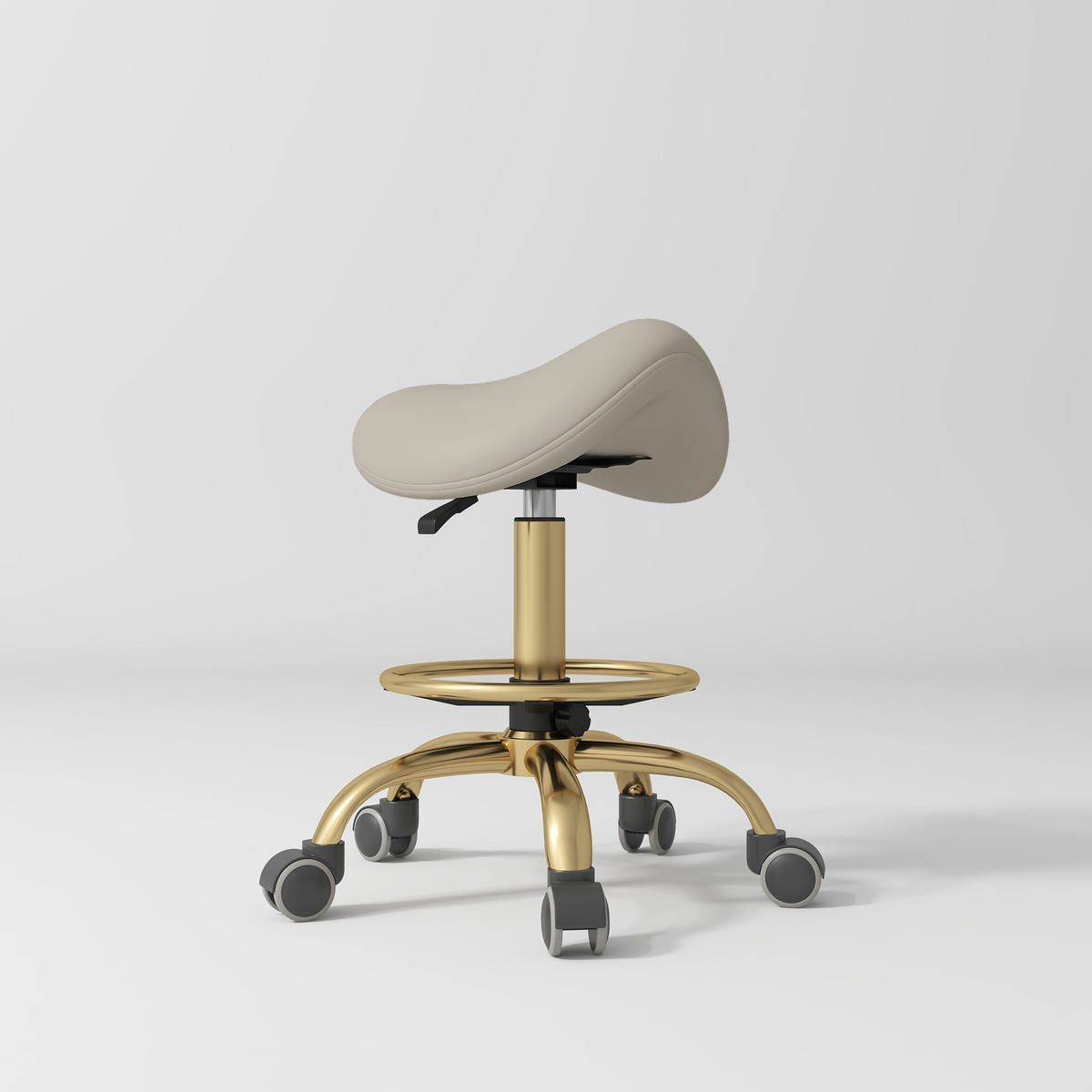 Manufakturo Selle Ergonomic Beauty Saddle Stool Stone Taupe - Gold Base - displayed in a professional treatment-room setting