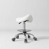 Manufakturo Selle Ergonomic Beauty Saddle Stool White - Silver Base - displayed in a professional treatment-room setting