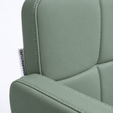 Close-up of Manufakturo Serenity Olive salon chair upholstery, showing the stitched padded backrest, armrest piping and woven Manufakturo label.