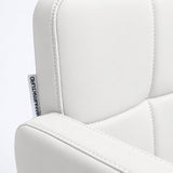 Close-up of Manufakturo Serenity White salon chair upholstery, showing the stitched padded backrest, armrest piping and woven Manufakturo label.
