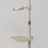 Close-up of the beige Manufakturo accessory tray clamped to a treatment lamp stand
