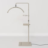 Full view of a beige Manufakturo treatment lamp with the accessory tray fitted to the stand