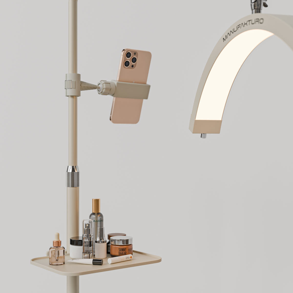 Beige Manufakturo accessory tray holding bottles and jars beside a treatment lamp with a phone in its holder