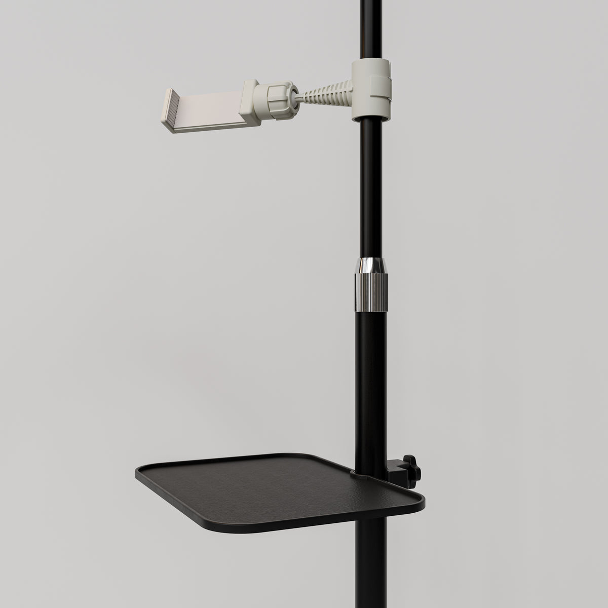 Close-up of the black Manufakturo accessory tray clamped to a treatment lamp stand