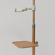 Close-up of the gold Manufakturo accessory tray clamped to a treatment lamp stand