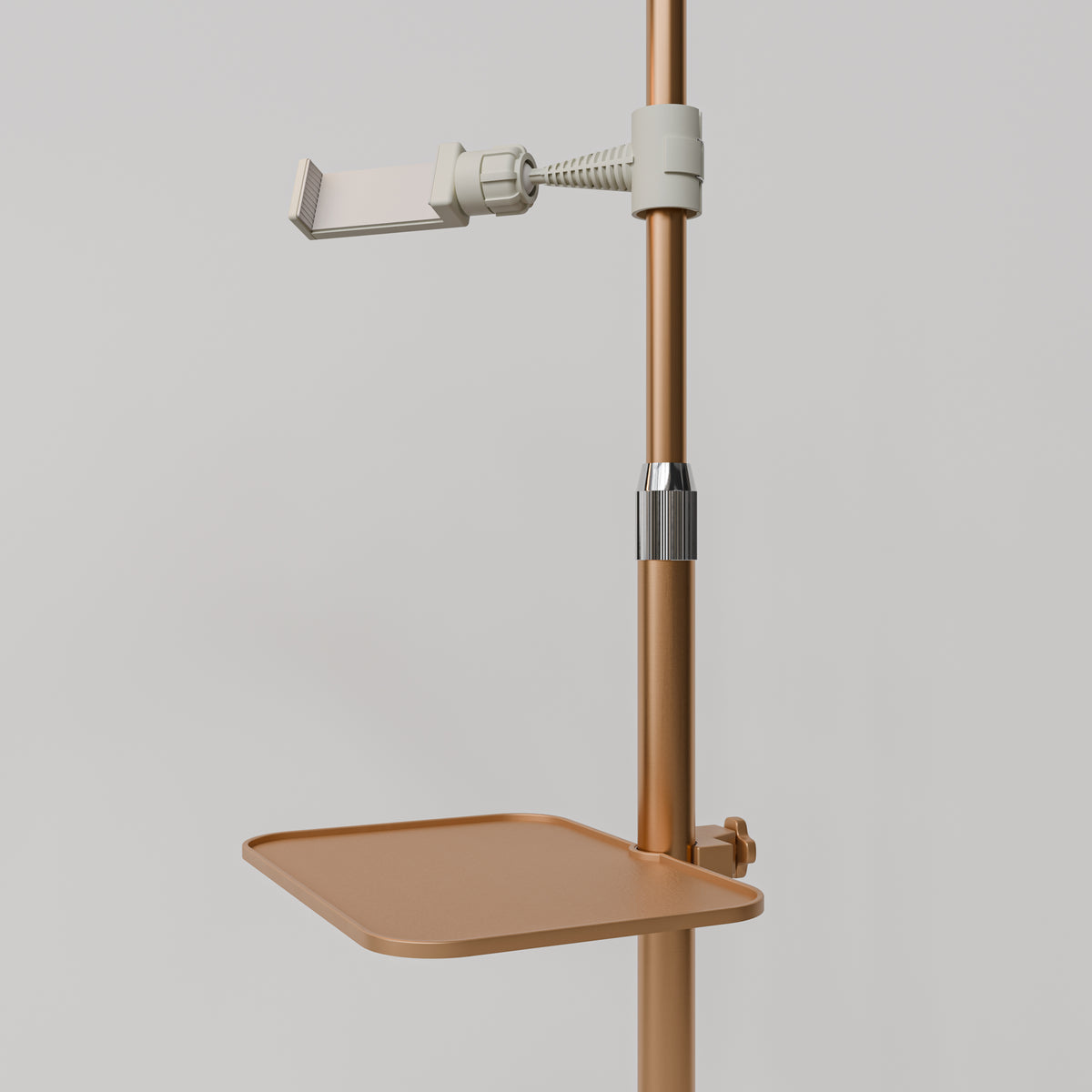 Close-up of the gold Manufakturo accessory tray clamped to a treatment lamp stand