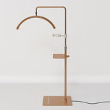 Full view of a gold Manufakturo treatment lamp with the accessory tray fitted to the stand