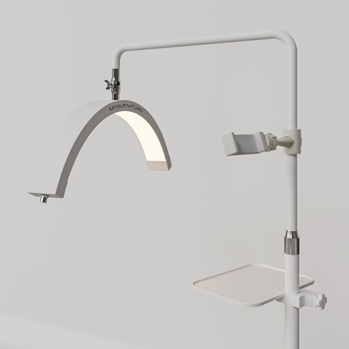 Angled view of the white Manufakturo accessory tray mounted below the treatment lamp