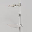 Close-up of the white Manufakturo accessory tray clamped to a treatment lamp stand