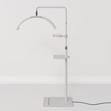 Full view of a white Manufakturo treatment lamp with the accessory tray fitted to the stand