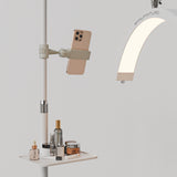 White Manufakturo accessory tray holding bottles and jars beside a treatment lamp with a phone in its holder