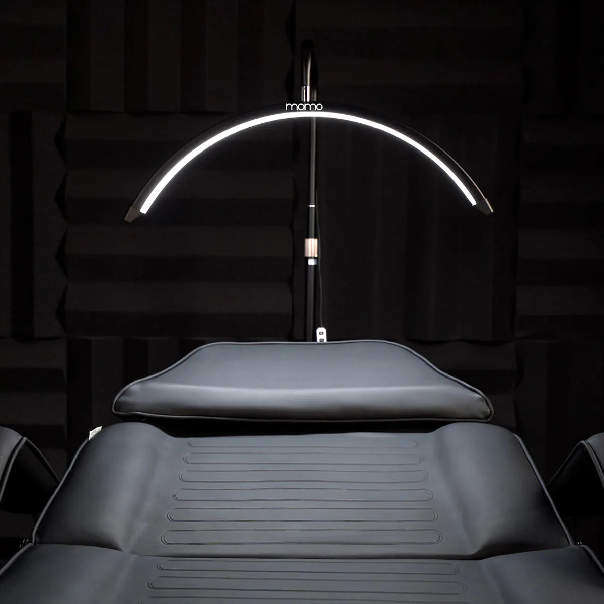 Momo MX6 curved LED lamp illuminating a salon treatment bed