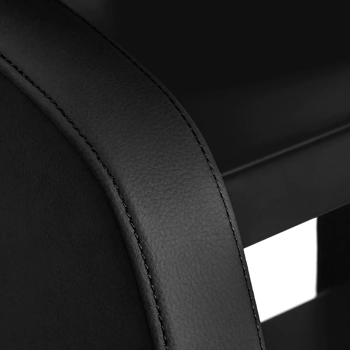 Close-up of the stitched black synthetic leather upholstery