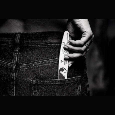 Victoria Vynn Client Whisperer 120/150 crescent nail file held in a monochrome lifestyle view