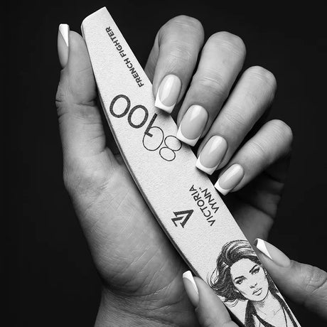 Victoria Vynn French Fighter 80/100 crescent nail file held beside a finished French manicure