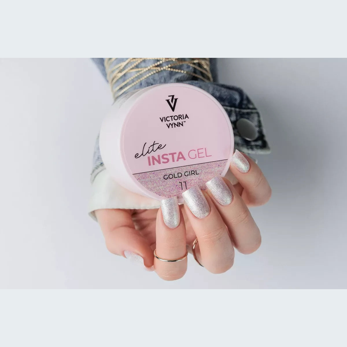 Victoria Vynn Insta Gel 11 Gold Girl pot held beside a sparkling pale pink manicure