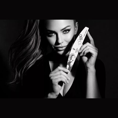 Model holding a Victoria Vynn Speed Goddess 100/180 crescent nail file in a black and white lifestyle image