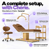 Manufakturo Chérie Caramel four-piece salon set features: treatment bed, matching salon chair, V3 Pro Gold lamp and gold three-tier beauty trolley.